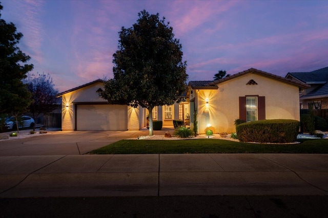 view of front of home with stucco siding, concrete driveway, and a garage