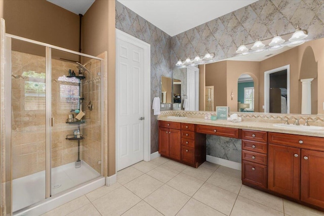 full bathroom with double vanity, a stall shower, and a sink