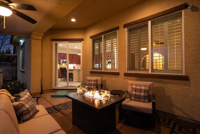 view of patio / terrace with a ceiling fan and a fire pit