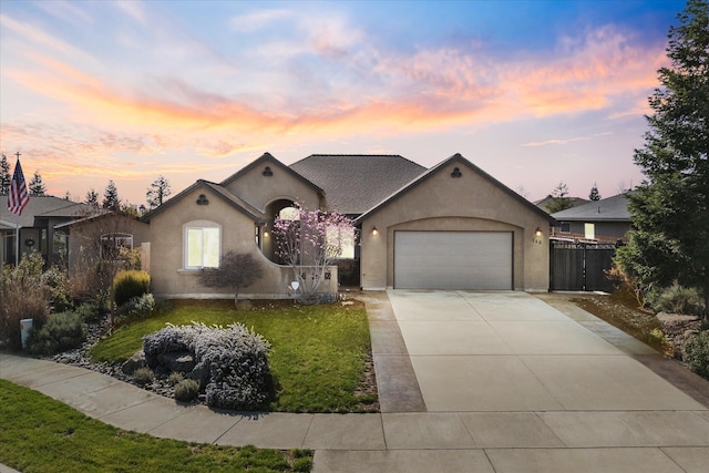 view of front of property with stucco siding, concrete driveway, an attached garage, and fence