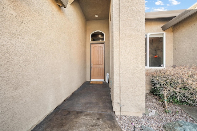 doorway to property featuring stucco siding