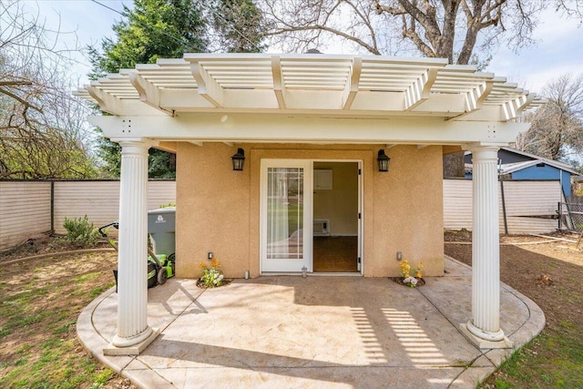 6040 Hornbeck Ln, Anderson, CA 96007 - view of exterior entry featuring a patio, fence, a pergola, and stucco siding