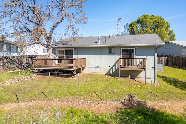 back of house with a fenced backyard, central air condition unit, a lawn, and a deck