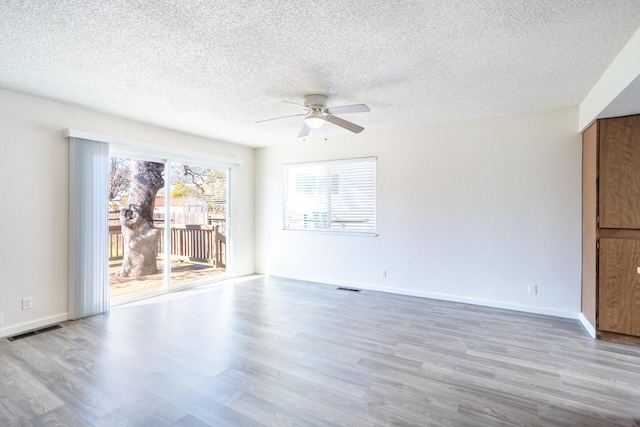 spare room featuring visible vents, baseboards, wood finished floors, and a ceiling fan