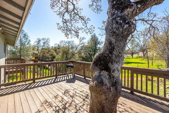 wooden terrace featuring a yard