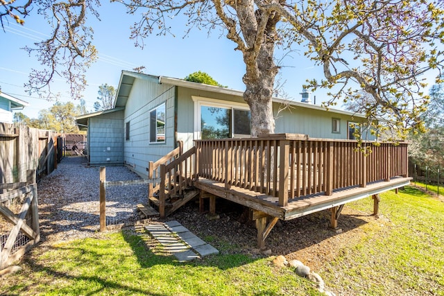 back of house with a deck, a yard, and a fenced backyard