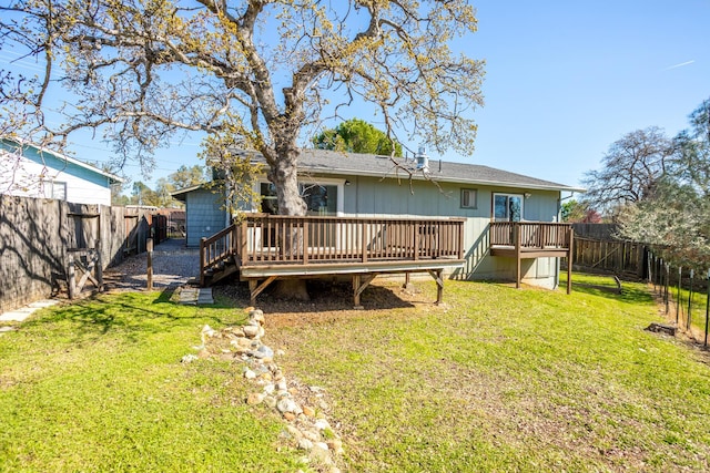 back of house with a deck, a fenced backyard, and a lawn