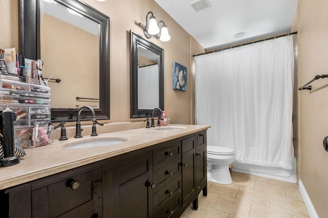 full bathroom featuring double vanity, toilet, visible vents, and a sink