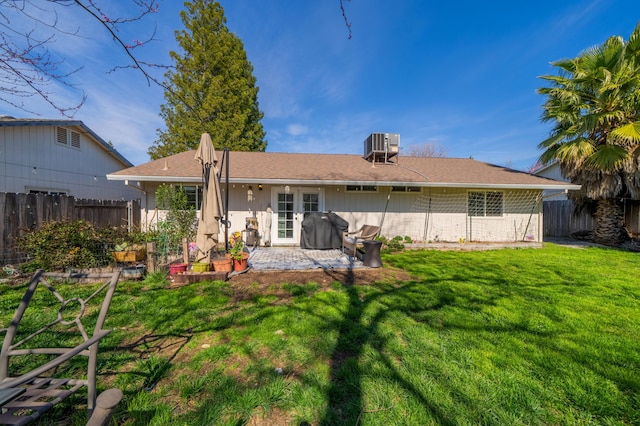 rear view of house with a lawn, a patio, central AC, and fence