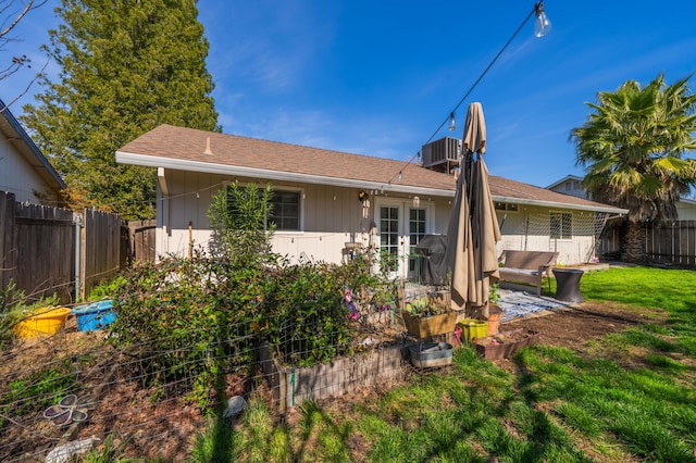 back of house with a yard, central air condition unit, french doors, and a fenced backyard