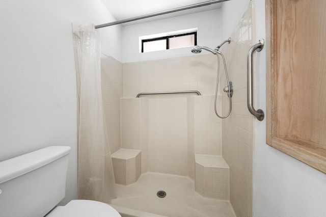 bathroom featuring toilet and a stall shower