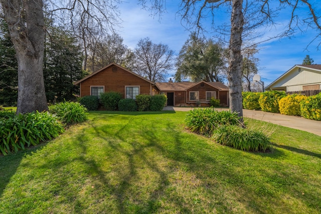 single story home featuring a front lawn and concrete driveway