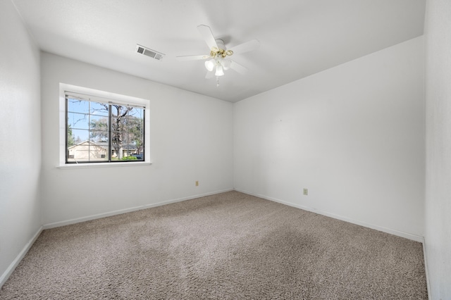 carpeted empty room featuring visible vents, baseboards, and a ceiling fan