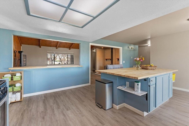 kitchen with open shelves, butcher block counters, light wood finished floors, baseboards, and vaulted ceiling with beams