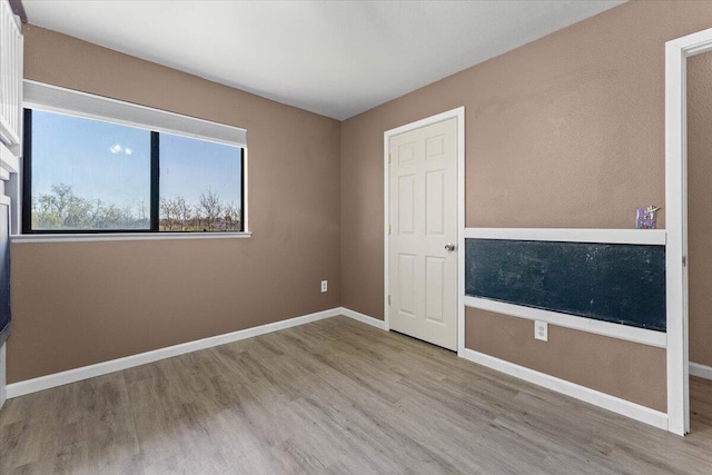 empty room featuring baseboards and wood finished floors