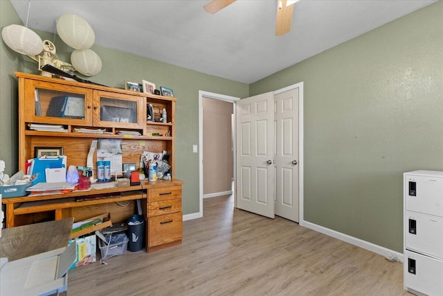 home office with baseboards, light wood-style floors, and a ceiling fan