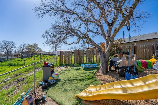 view of yard featuring a playground and fence