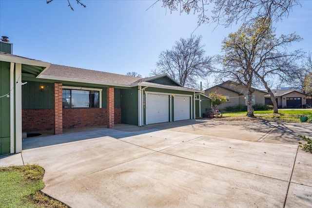 view of home's exterior with a garage, brick siding, and driveway