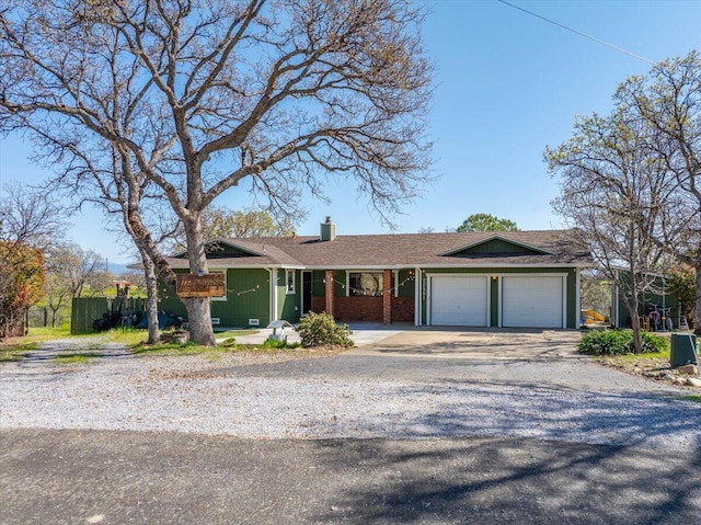 ranch-style house featuring concrete driveway, brick siding, a garage, and a chimney