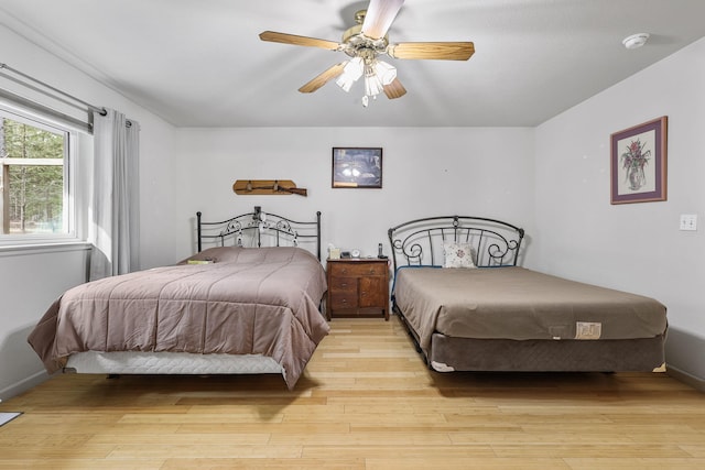 bedroom featuring ceiling fan, light wood-type flooring, and baseboards