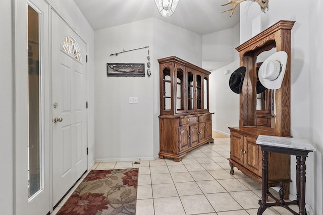 foyer entrance with baseboards and light tile patterned flooring