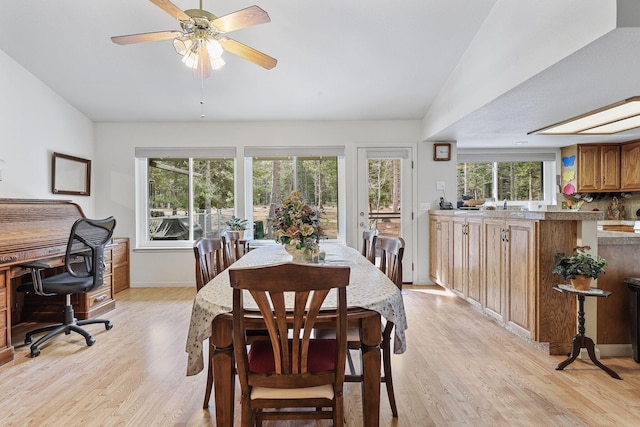 dining space with a wealth of natural light, baseboards, light wood-type flooring, and a ceiling fan