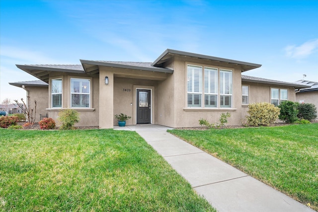 view of front of house featuring stucco siding and a front yard