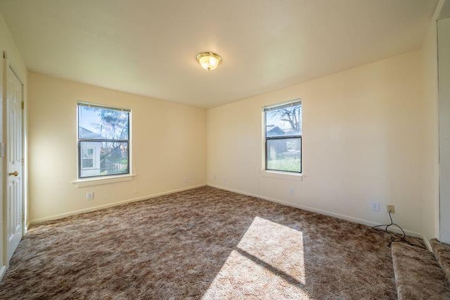 unfurnished room featuring carpet and baseboards