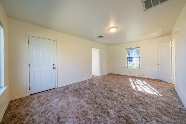 unfurnished bedroom featuring visible vents, baseboards, and carpet
