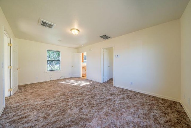 unfurnished bedroom with carpet flooring, baseboards, and visible vents