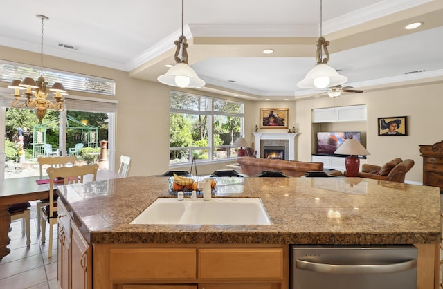 kitchen with visible vents, crown molding, open floor plan, dishwasher, and a lit fireplace