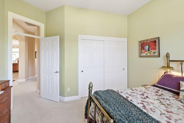 bedroom with light carpet, arched walkways, baseboards, and a closet