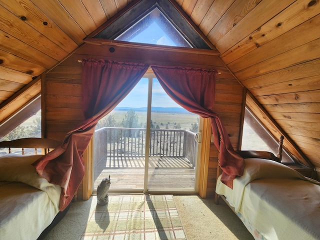 bedroom with access to exterior, wooden walls, carpet, wooden ceiling, and a mountain view