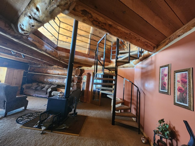 staircase featuring beam ceiling, log walls, a wood stove, and carpet