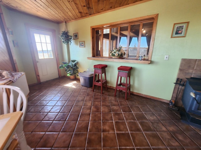 interior space with wood ceiling, baseboards, and dark tile patterned flooring