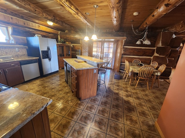 kitchen featuring beamed ceiling, refrigerator with ice dispenser, a breakfast bar area, wood ceiling, and dishwasher