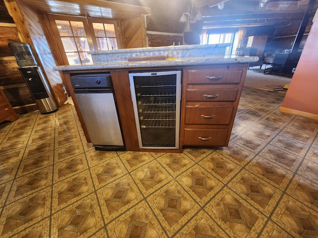 kitchen featuring beverage cooler and light stone counters