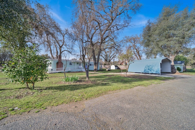 view of yard with a carport, driveway, and fence