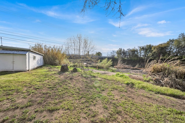 view of yard featuring an outdoor structure and a shed