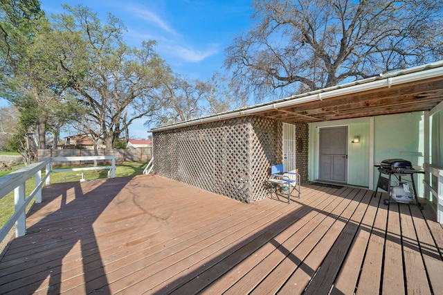 wooden deck featuring fence and a grill