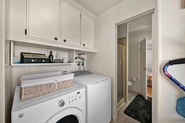 clothes washing area with washer and clothes dryer and cabinet space