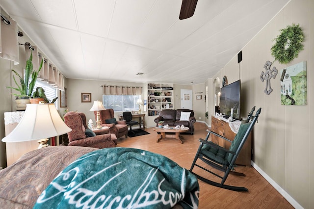 living room featuring built in features, baseboards, and light wood finished floors