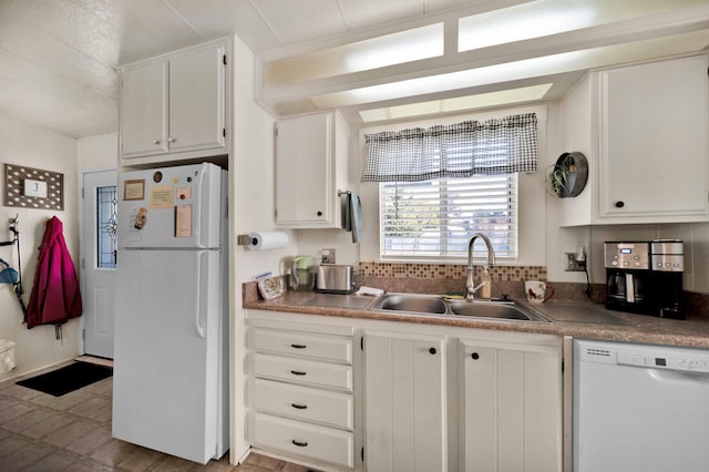 kitchen featuring white appliances, white cabinets, and a sink