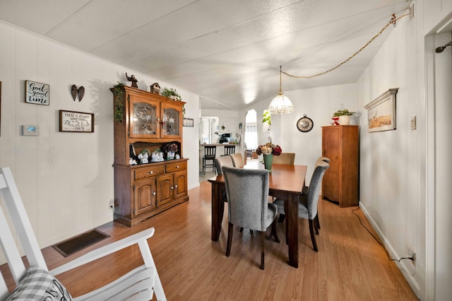 dining area featuring baseboards, visible vents, and light wood-type flooring