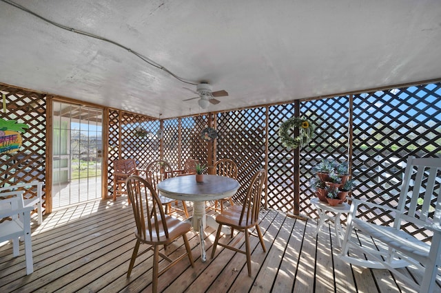 wooden terrace with outdoor dining space and ceiling fan