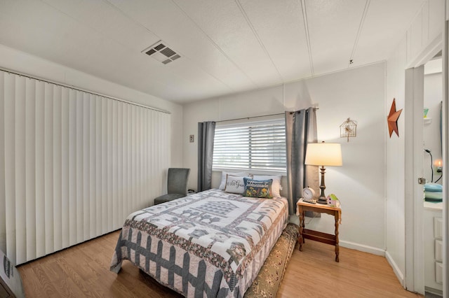 bedroom featuring visible vents, baseboards, and light wood-style floors