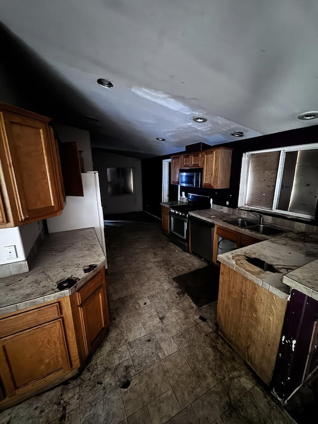 kitchen featuring a sink, light countertops, brown cabinetry, and stainless steel appliances