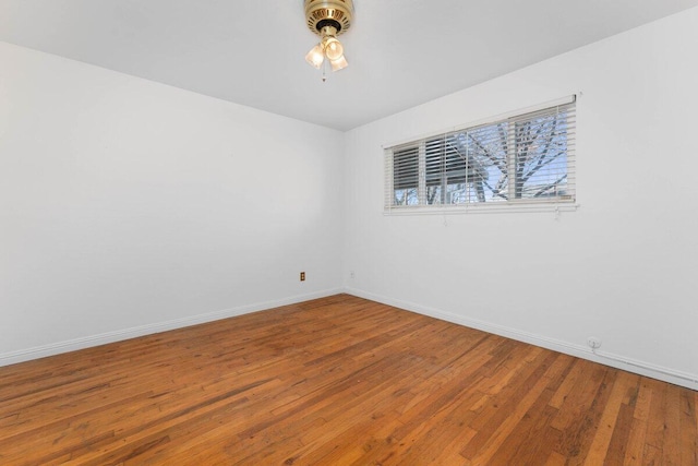 empty room with ceiling fan, baseboards, and hardwood / wood-style flooring