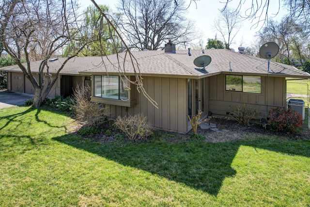 view of front of house featuring board and batten siding, a chimney, a front yard, and a shingled roof