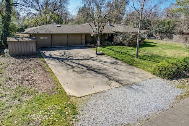 ranch-style home featuring a garage, concrete driveway, a front yard, and fence